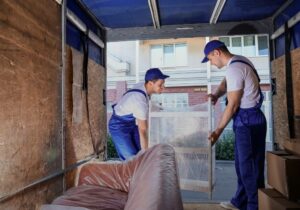 Möbelpacker laden verpackte Möbel in LKW.